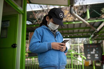 Santiago Medino utiliza su teléfono, recién donado por la campaña de Tiberio Malaiu. La educación presencial fue suspendida desde el inicio de la pandemia en Chile en marzo de 2020 y todavía no ha regresado a la normalidad.