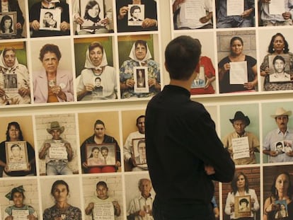 Una persona observa algunas de las imágenes que componen la exposición 'Desaparecidos', de Gervasio Sánchez.