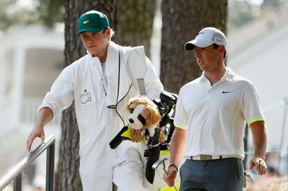 El cantante de One Direction Niall Horan carga con los palos del golfista Rory McIlroy durante el torneo en Augusta.
