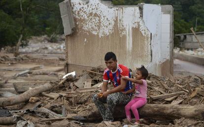 Un padre y su hija en mitad de la desolaci&oacute;n de Mocoa.