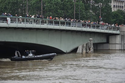 Varias personas observan el río Sena en París.