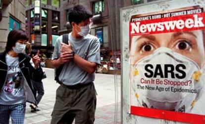 Transeúntes en Hong Kong con mascarillas para protegerse contra la neumonía atípica miran un anuncio de la portada de la revista <i>Newsweek</i> dedicada a la epidemia<i>.</i>