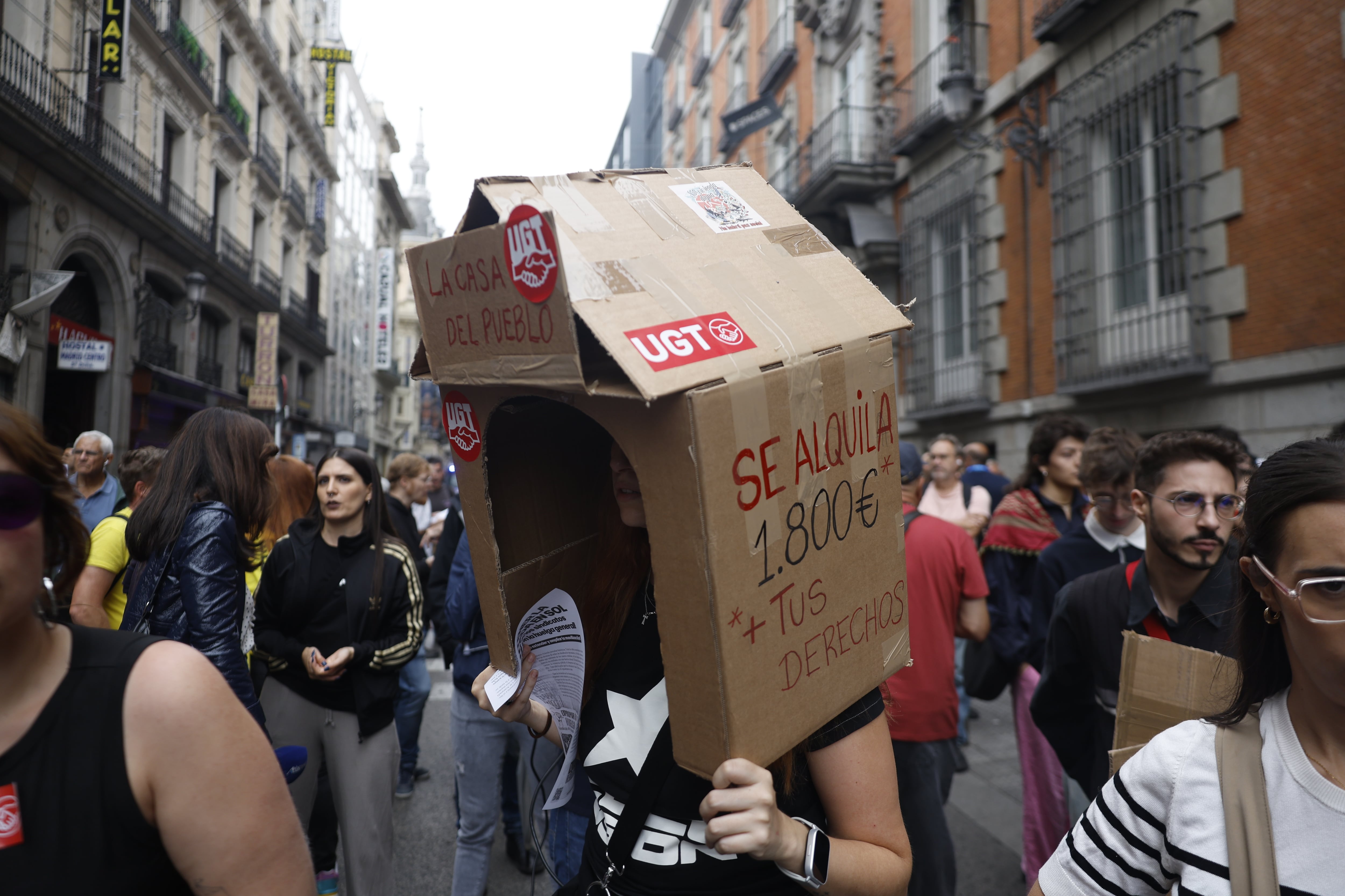 Una persona sostiene una casa de cartón en la manifestación frente al Congreso.