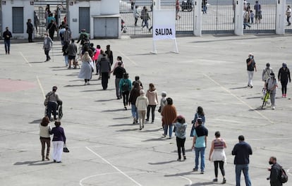 La votación está marcada por el estallido social -un dispositivo de casi 50.000 militares y policías custodiarán los centros de votación y sus alrededores-, pero también por la pandemia. En la imagen, un grupo de votantes espera su turno en la capital.