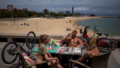 Local customers sit in a restaurant next to a beach in Barcelona.