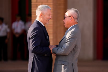 El ministro del Interior, Fernando Grande-Marlaska, junto al secretario general adjunto de Asuntos Económicos y Sociales de las Naciones Unidas, Junhua Li, (d) durante la ceremonia de izado de bandera en Sevilla, este domingo.
