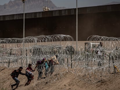 Migrantes cruzan el alambre de púas en la frontera de Ciudad Juárez, en mayo 2023.