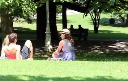 Una pareja toma el sol en el parque de Doña Casilda de Bilbao esta mañana