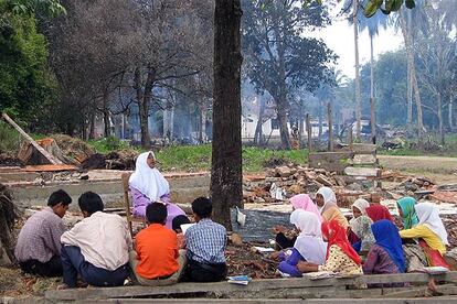 Varios niños reciben clase al aire libre en Datar Luah, un pueblo de la costa de Sumatra arrasado por el maremoto.