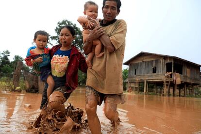 Una familia abandona su vivienda anegada por las inundaciones tras el colapso de la represa Xepian-Xe Nam Noy, en la provicinia de Attepeu (Laos).