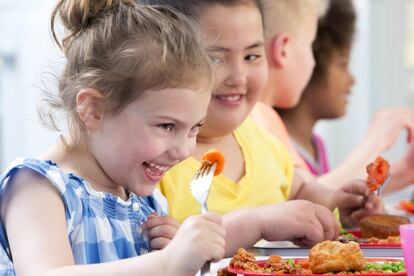 Happy school children enjoying their school dinners