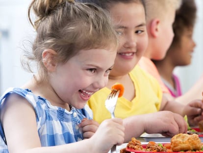 Happy school children enjoying their school dinners