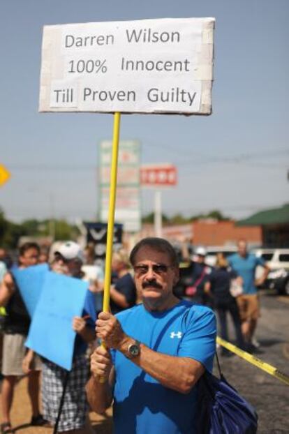 Un manifestante muestra un letrero en favor del policía Darren Wilson.