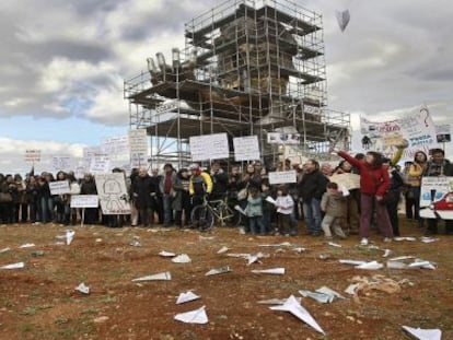 Los concentrados en el aeropuerto de Castellón lanzan aviones de papel junto a la escultura de Juan Ripollés con la cara de Carlos Fabra.