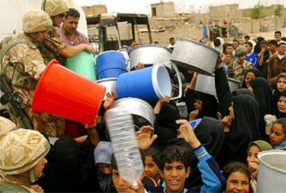 Un grupo de iraquíes se pelean por conseguir agua que reparten soldados británicos, ayer en Basora.