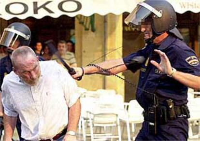 Un polica golpea a un hombre, ayer en Pamplona.