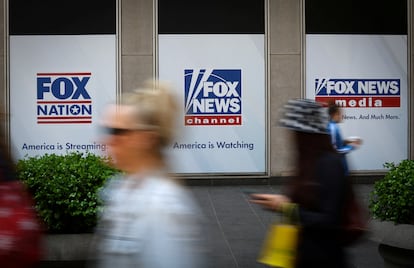 People walk past Fox News posters on the exterior of the News Corporation and Fox News headquarters building in Manhattan in New York City, New York, on April 24, 2023.