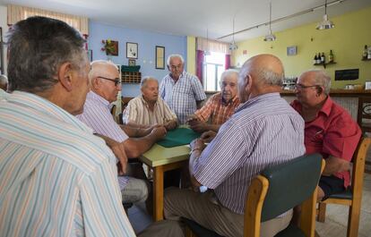 Varios mayores juegan a las cartas en el centro de la tercera Edad de Palomares, algunos de ellos vieron caer las bombas.