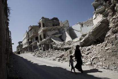 Em 3 de setembro de 2013, uma menina e uma mulher passam por edifícios destruídos na cidade de Maarat al-Numaan, na província de Idlib. Até então, o conflito na República Árabe Síria havia provocado o deslocamento interno de 4,25 milhões de pessoas. O apoio do Unicef no país se concentrava então em programas de água, saneamento e higiene, incluindo o fornecimento de água potável e para uso doméstico para 10 milhões de pessoas; proteção infantil, incluindo serviços de apoio psicossocial; e nutrição e saúde. Embora muitas crianças já estivessem refugiadas em outros países, mais de meio milhão de crianças não iam à escola na Síria. Por isso, o organismo da ONU se esforçou também para garantir a continuidade da educação.