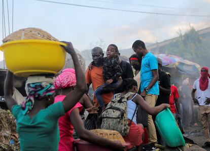En los últimos días, varias zonas del país han estado envueltas en protestas y disturbios en una espiral permanente de inestabilidad política. En la imagen, grupos de personas atraviesan una barricada durante una manifestación en contra del Gobierno haitiano, el 3 de octubre de 2022, en Puerto Príncipe. 