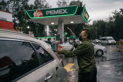 trabajador sostiene una bomba de combustible en una gasolinera de Petróleos Mexicanos en Naucalpan, Estado de México, en agosto de 2022.