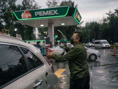 Un trabajador sostiene una bomba de combustible en una gasolinera de Petróleos Mexicanos en Naucalpan, Estado de México, en agosto de 2022.