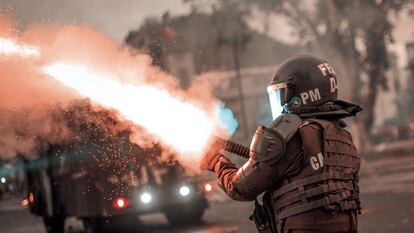 Un agente de la Policía chilena dispara su carabina lanza gases durante una protesta en 2019.