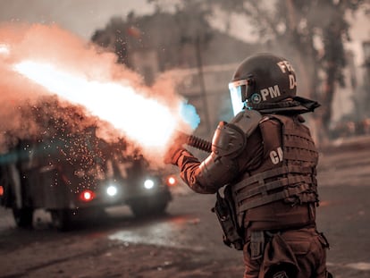 Un agente de la Policía chilena dispara su carabina lanza gases durante una protesta en 2019.