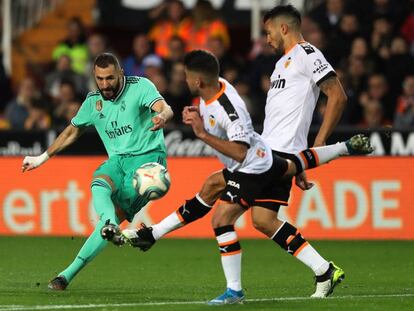 Benzema remata a portería ante Garay y Costa.