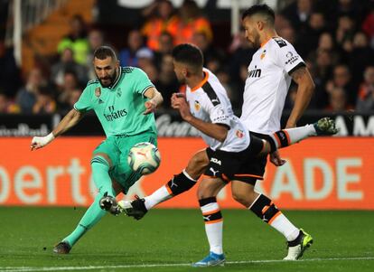 Benzema remata a portería ante Garay y Costa.