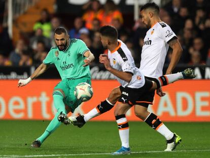 Benzema remata a portería ante Garay y Costa.