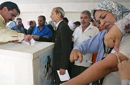 Una mujer se extrae sangre en un colegio electoral de Bagdad para marcar con ella la casilla del <b></b><i>sí</i> en apoyo a Sadam Husein.