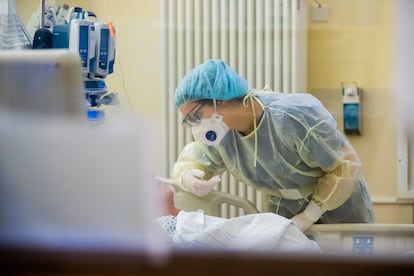 Una trabajadora sanitaria habla con un paciente en una unidad hospitalaria.