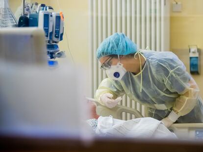 Una trabajadora sanitaria habla con un paciente en una unidad hospitalaria.