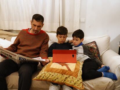 Varios miembros de una familia leen un diario en papel y usan una tableta.