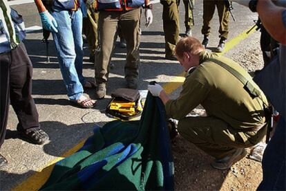 Un soldado israelí examina el cuerpo sin vida del joven colono, tirado en una carretera cerca de Hebrón.