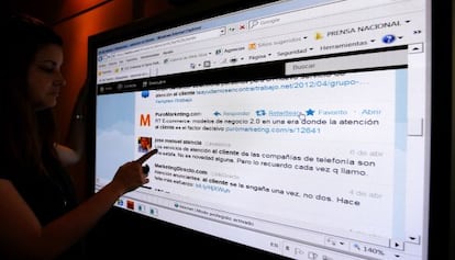 Una joven, ante una pantalla con comentarios en la red social Twitter.