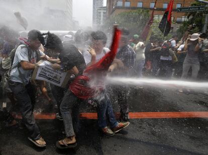 La policía utiliza un cañón de agua para dispersar a unos manifestantes que protestan por la próxima visita del presidente de los Estados Unidos, Barack Obama, a Manila (Filipinas).