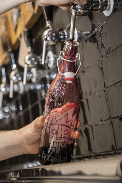 Rellenando una botella con vino a granel en La Caníbal, de Madrid. Imagen proporcionada por el bar.