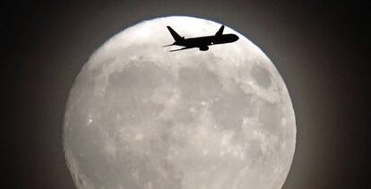 Un avión pasa frente a la Luna cerca del aeropuerto londinense de Heathrow, ayer.