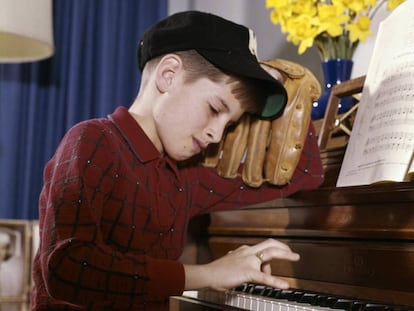 Ni&ntilde;o en clase de piano, pero deseando jugar al b&eacute;isbol 