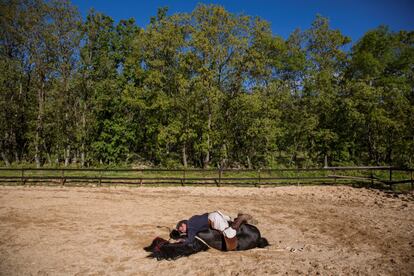 Fernando Noailles, terapeuta emocional, deitado junto do seu cavalo em Guadalix de la Sierra (Espanha).