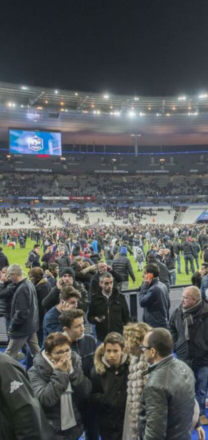 Espectadores del Francia-Alemania, tras el partido, en el césped de Saint Dennis.