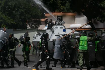 Una tanqueta trata de dispersar a quienes participaron de la protesta usando un cañón de agua.
