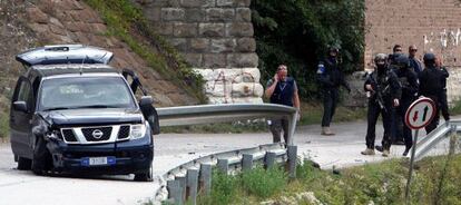 Polic&iacute;as de la misi&oacute;n de la UE en Kosovo aseguran la zona junto al veh&iacute;culo emboscado. 