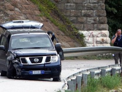 Polic&iacute;as de la misi&oacute;n de la UE en Kosovo aseguran la zona junto al veh&iacute;culo emboscado. 