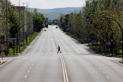 Un hombre camina por una avenida desierta de Córdoba.