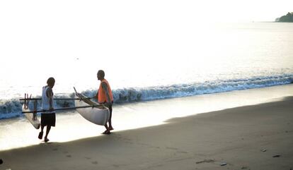 Dos pescadores de Vanuatu lanzan al agua su embarcación.