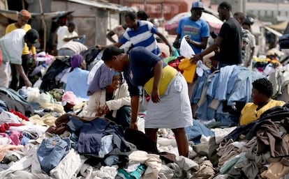Haitianos compram roupa em um mercado de rua.