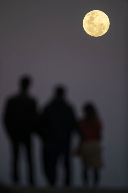 La luna llena se eleva cerca de la playa de Bondi de Sídney antes del eclipse lunar.